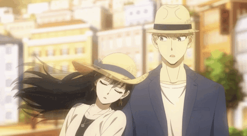 A Man And A Woman Are Standing Next To Each Other On A City Street . GIF