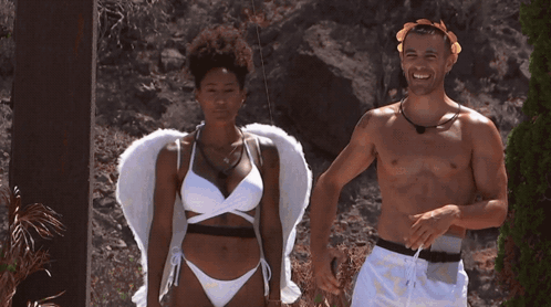 A Man And A Woman Are Standing Next To Each Other On A Deck GIF
