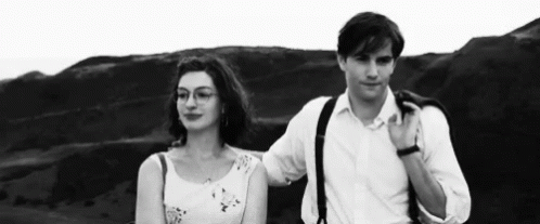 A Man And A Woman Are Standing Next To Each Other On A Hill . GIF