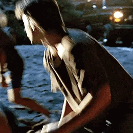 A Man And A Woman Are Standing Next To Each Other On A Sidewalk . GIF