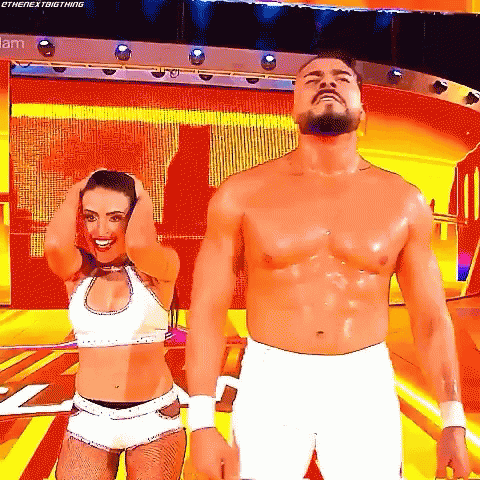 A Man And A Woman Are Standing Next To Each Other On A Stage With Their Hands In Their Hair . GIF