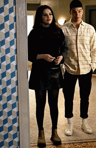 A Man And A Woman Are Standing Next To Each Other On A Tiled Floor GIF