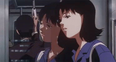 A Man And A Woman Are Standing Next To Each Other On A Train . GIF