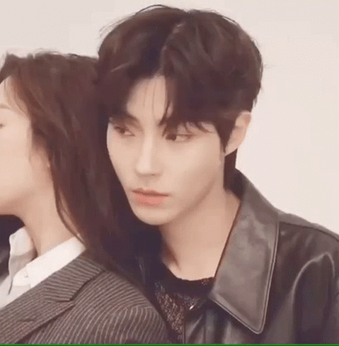A Man And A Woman Are Standing Next To Each Other . The Man Is Wearing A Leather Jacket . GIF