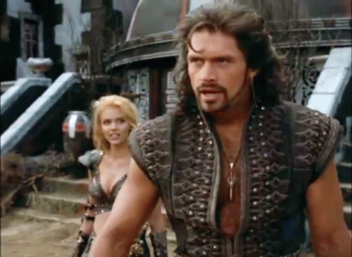 A Man And A Woman Are Standing Next To Each Other . GIF