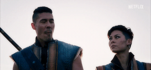 A Man And A Woman Are Standing Next To Each Other With A Netflix Logo In The Corner GIF