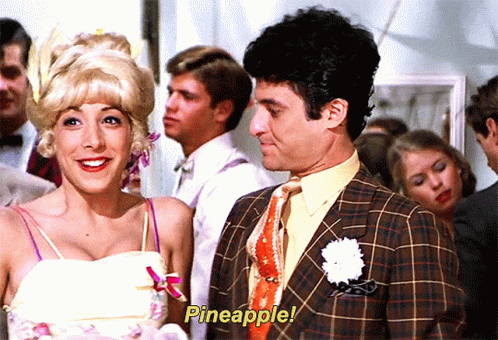 A Man And A Woman Are Standing Next To Each Other With Pineapple Written On The Screen GIF