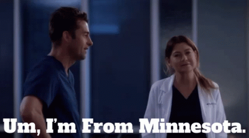 A Man And A Woman Are Standing Next To Each Other With The Words Um I 'M From Minnesota Behind Them GIF