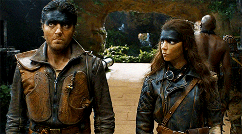 A Man And A Woman Are Standing Next To Each Other With Their Faces Painted Black GIF