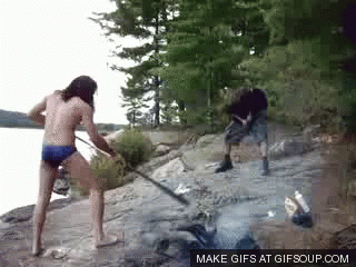 A Man And A Woman Are Standing On A Rocky Shore . GIF