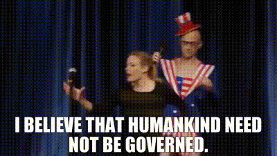 A Man And A Woman Are Standing On A Stage With A Microphone In Their Hands . GIF