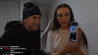 a man and a woman are taking a picture of each other with a cell phone .