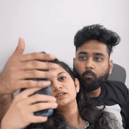 A Man And A Woman Are Taking A Selfie With Their Cell Phone GIF