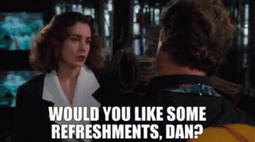 A Man And A Woman Are Talking To Each Other And The Woman Is Asking The Man If He Would Like Some Refreshments . GIF