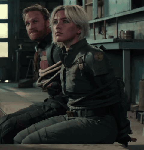 Tied Up Man And Woman In Room Looking At Each Other GIF