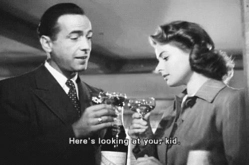 a man and a woman are toasting with wine glasses . the man is holding a bottle of wine .