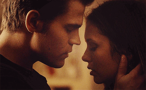 A Man And A Woman Are Touching Their Faces GIF