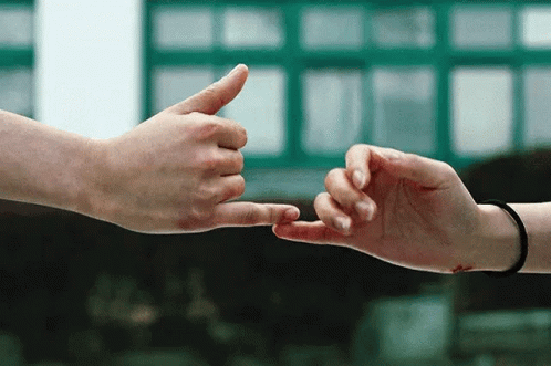 A Man And A Woman Are Touching Their Fingers GIF