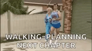 A Man And A Woman Are Walking Down A Sidewalk Next To Each Other . GIF