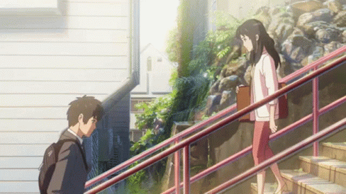 A Man And A Woman Are Walking Down Stairs GIF