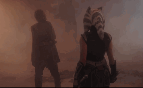 A Man And A Woman Are Walking Through A Foggy Area GIF