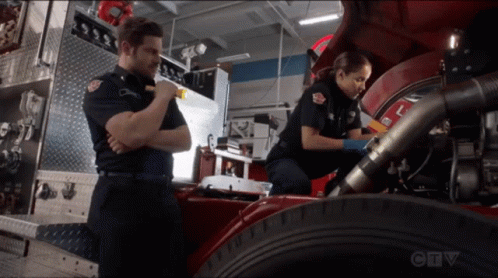 A Man And A Woman Are Working On A Fire Truck With A Ctv Logo In The Background GIF