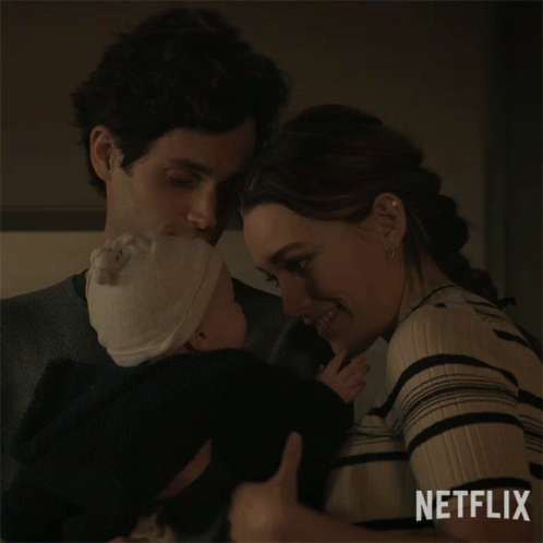 A Man And A Woman Holding A Baby With Netflix Written On The Bottom GIF