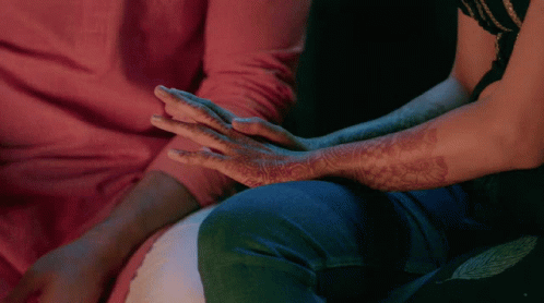 A Man And A Woman Holding Hands With Henna On Their Arms GIF