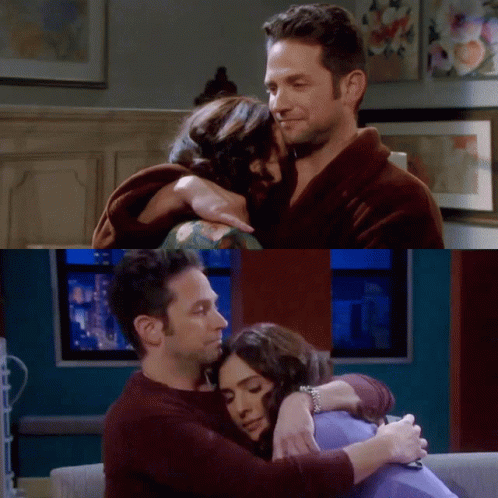 A Man And A Woman Hugging Each Other In A Living Room GIF