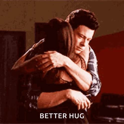 A Man And A Woman Hugging Each Other With The Words `` Better Hug '' Written On The Bottom . GIF