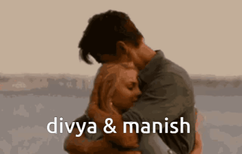 A Man And A Woman Hugging With The Words Divya & Manish Below Them GIF