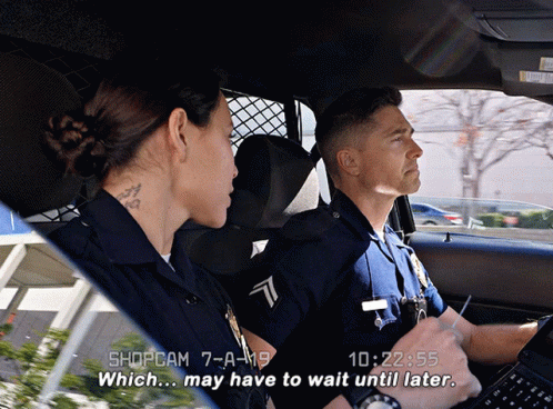 A Man And A Woman In A Police Car With The Time Of 10:22 On The Screen GIF