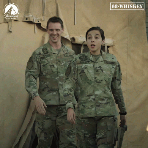 Man And Woman In Military Uniforms In Front Of GB Whiskey Sign GIF