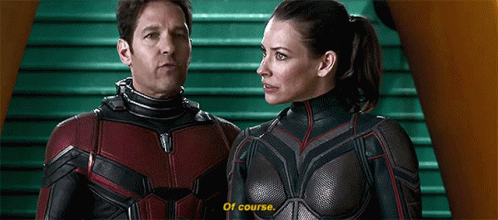 Man And Woman In Superhero Costumes On Green Staircase GIF