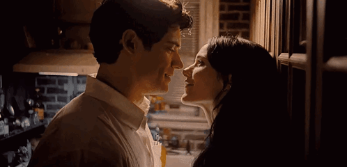 A Man And A Woman Kissing In A Kitchen . GIF