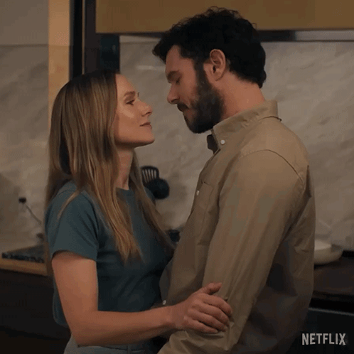 A Man And A Woman Kissing In A Kitchen With Netflix Written On The Bottom GIF
