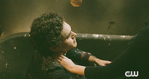 A Man And A Woman Kissing In The Rain With A Cw Logo Behind Them GIF