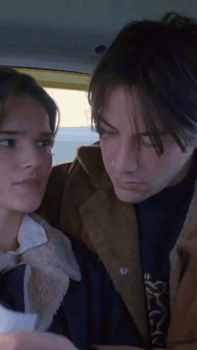 A Man And A Woman Looking At Each Other GIF