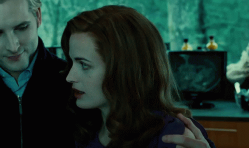 A Man And A Woman Looking At Each Other In A Dark Room GIF