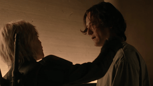 A Man And A Woman Looking At Each Other In The Dark GIF