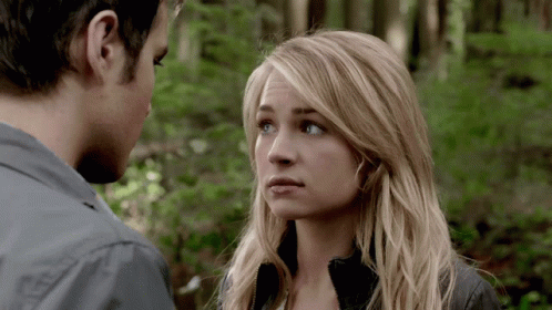 Man And Woman Looking At Each Other With Trees In Background GIF