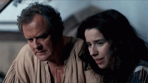 A Man And A Woman Looking At Something Together GIF