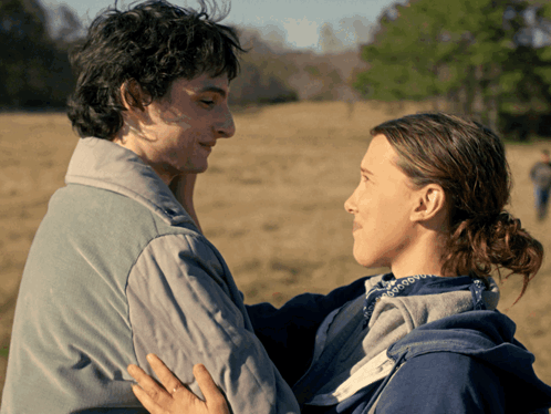 A Man And A Woman Looking Into Each Other 'S Eyes In A Field GIF