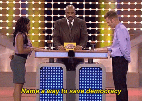 A Man And A Woman On A Game Show With The Words Name A Way To Save Democracy On The Bottom GIF