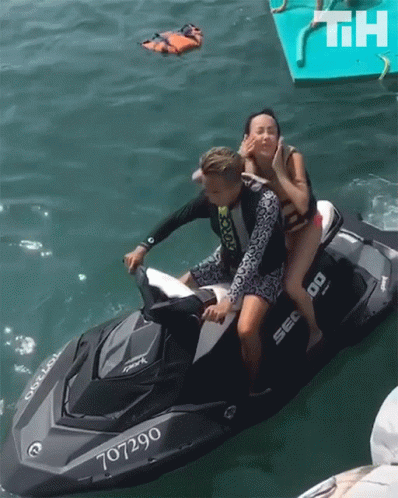 A Man And A Woman On A Jet Ski With The Number 707290 GIF