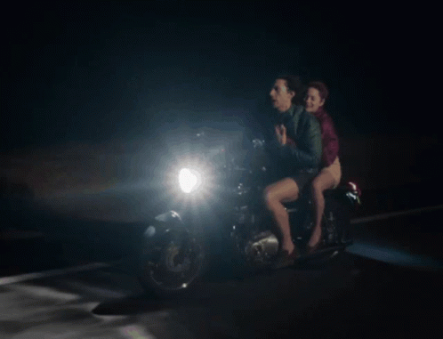 A Man And A Woman On A Motorcycle At Night GIF
