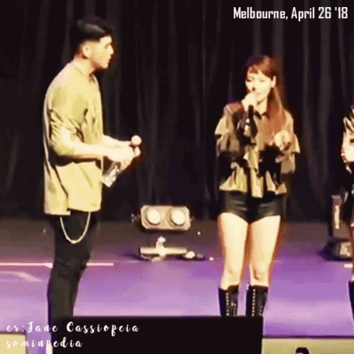 A Man And A Woman On A Stage With The Date April 26 18 GIF