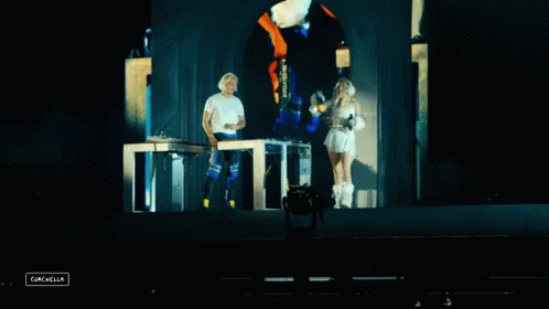 A Man And A Woman On A Stage With The Word Cancella In The Lower Right Corner GIF