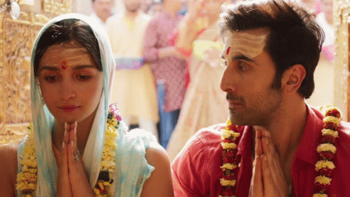 A Man And A Woman Praying In A Temple GIF