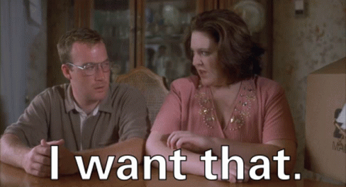 A Man And A Woman Sit At A Table With The Words I Want That GIF